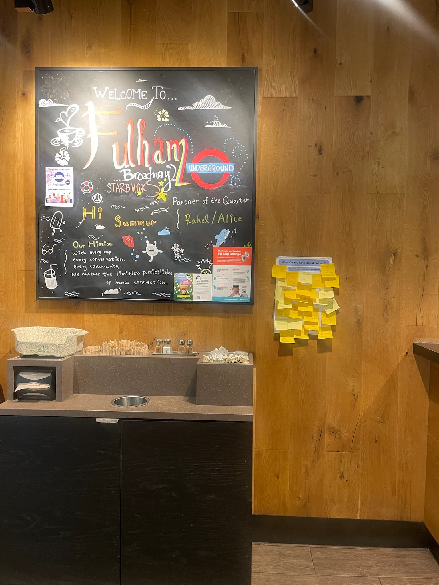 Starbucks Fulham Broadway 店內的黑板,旁邊是貼滿黃色便利貼的社區留言牆